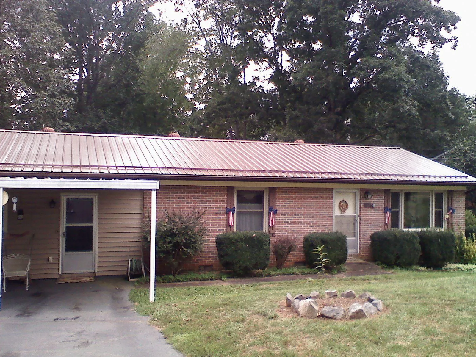Bronze metal roof and carport on a brick ranch home — Roof Repair work by our crew in Le Claire