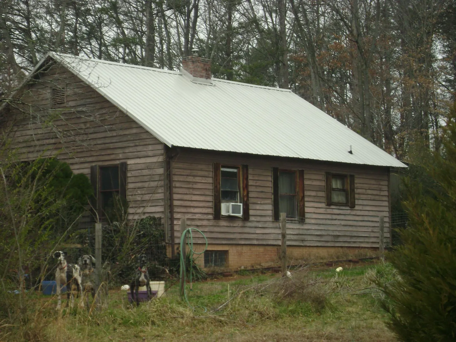 White metal roof on an old wood sided farmhouse, from a Metal Roof Installation job in Le Claire